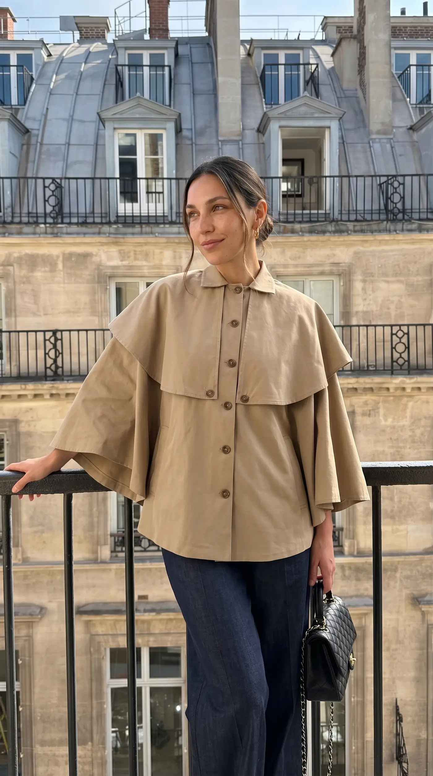 Veste-cape courte portée sur un balcon parisien
